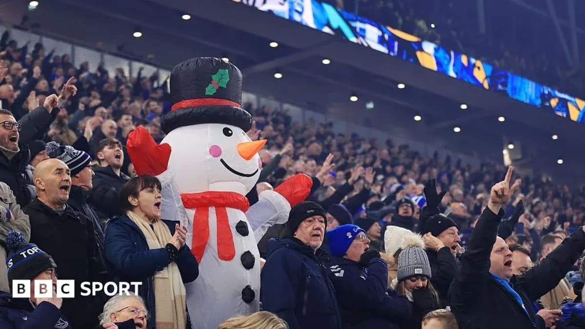 Fans cheering with a large snowman mascot