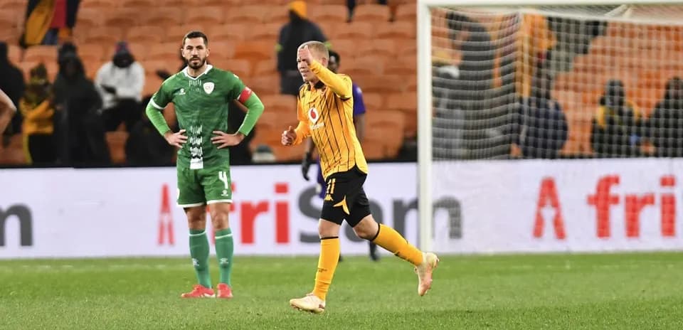 Player celebrating while another looks on, stadium background