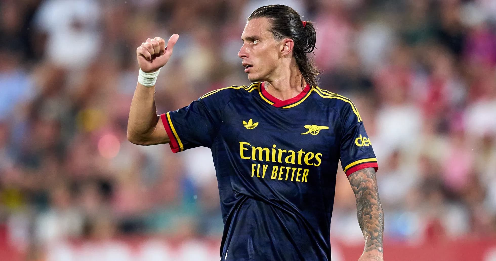 Player gesturing during match in Arsenal jersey