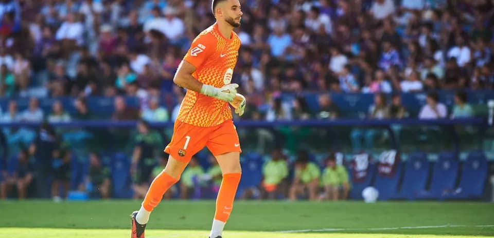 Goalkeeper in orange kit running on the field
