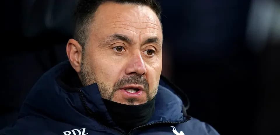 Coach wearing Tottenham jacket during a match