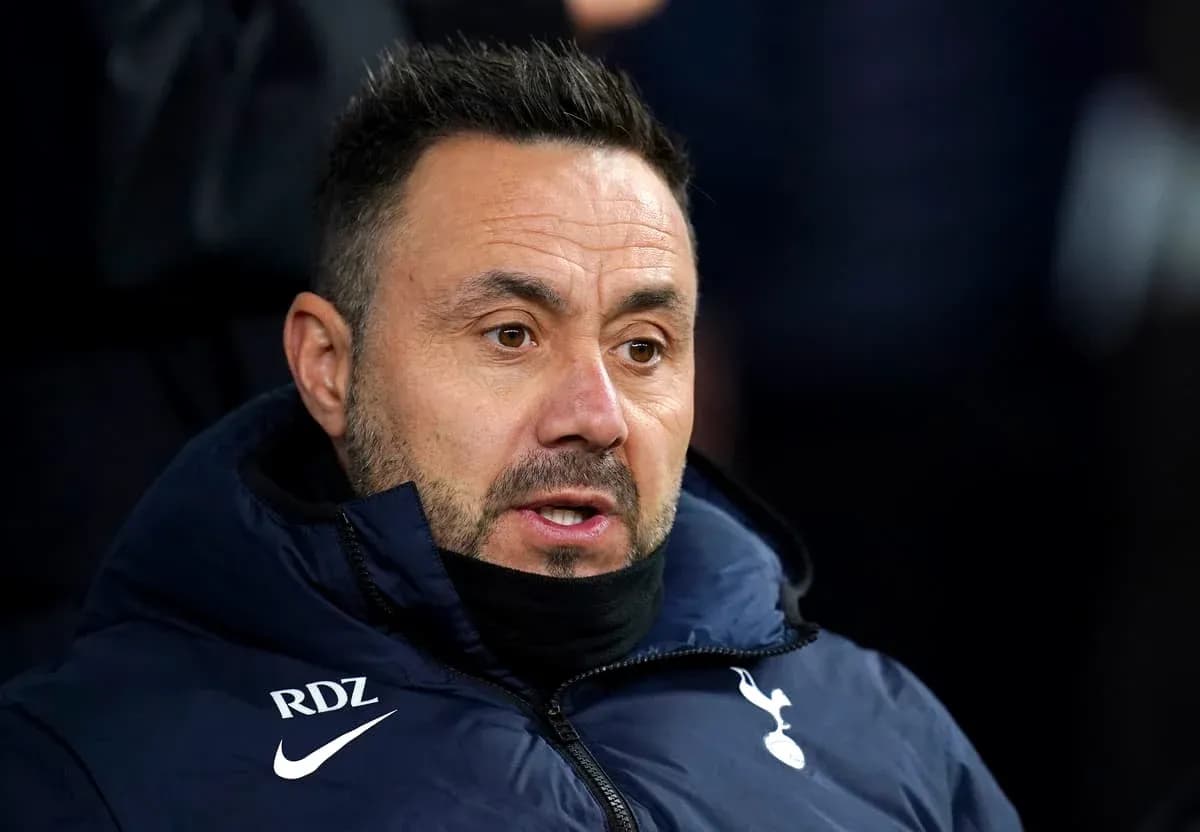Coach wearing Tottenham jacket during a match