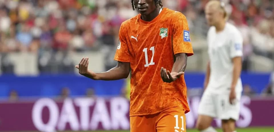Player gesturing during a match in orange jersey