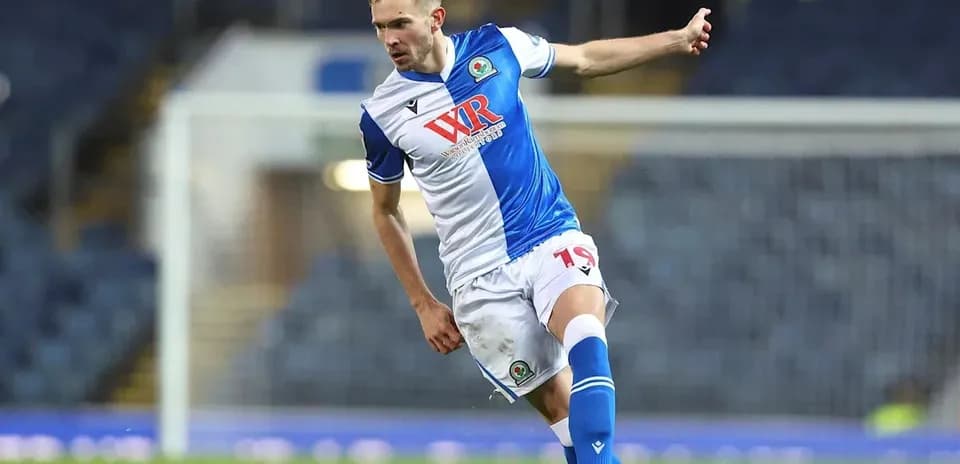 Player in blue and white kit kicking a soccer ball