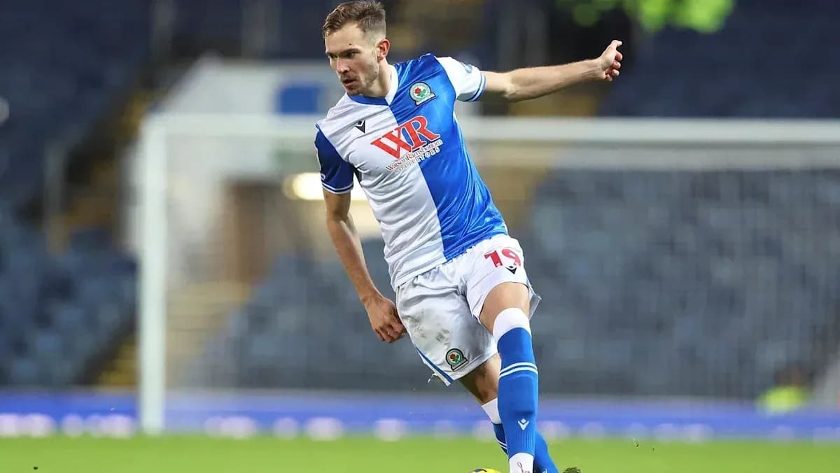 Player in blue and white kit kicking a soccer ball