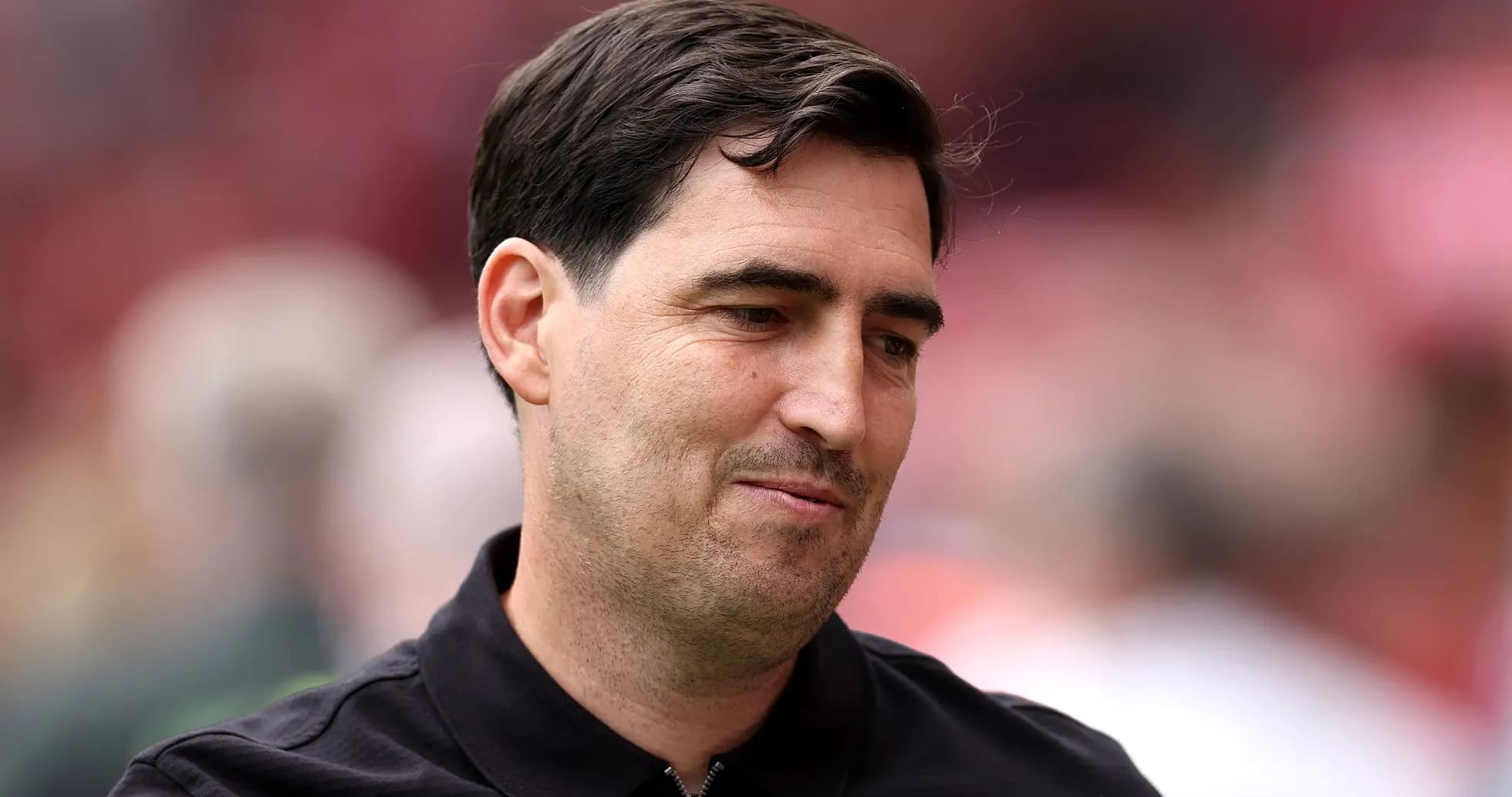 Coach in black shirt at stadium event