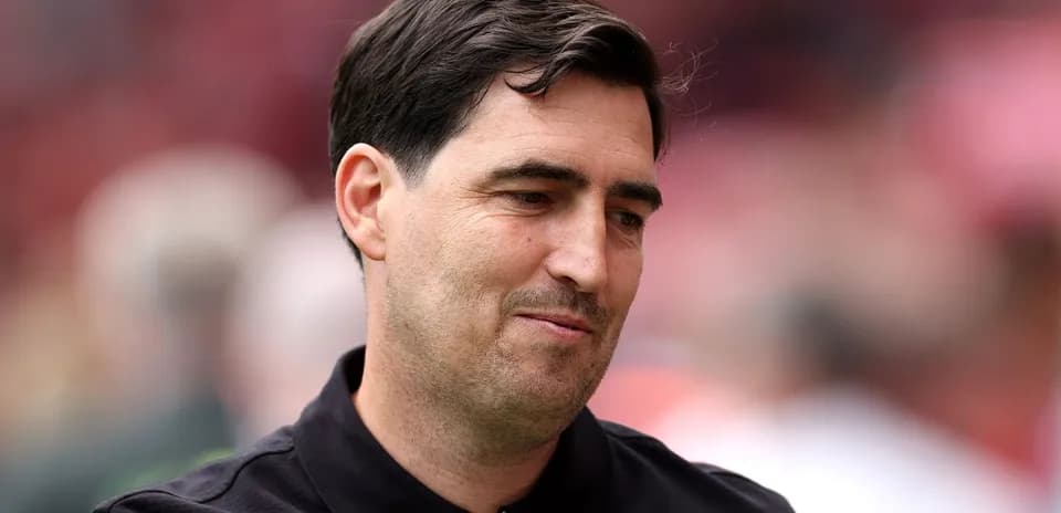 Coach in black shirt at stadium event