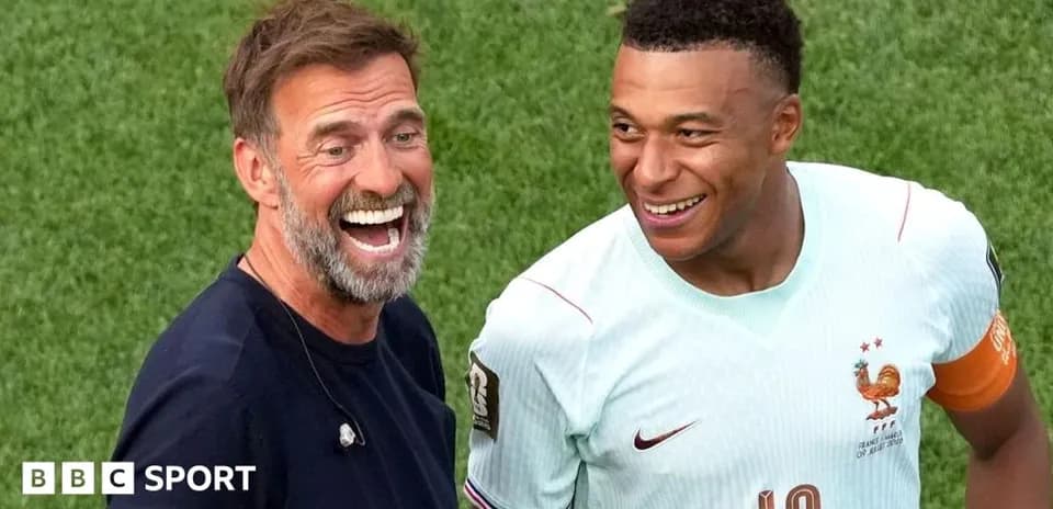 Coach and player smiling on the field after match