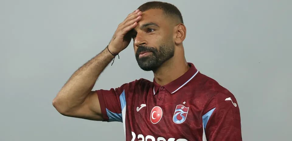 Player in maroon jersey touching his forehead