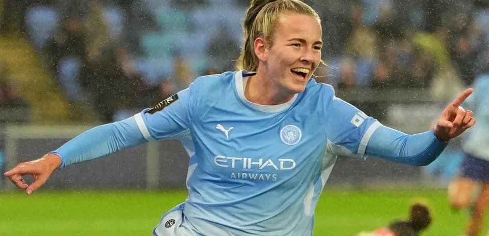 Player celebrating a goal in Manchester City kit