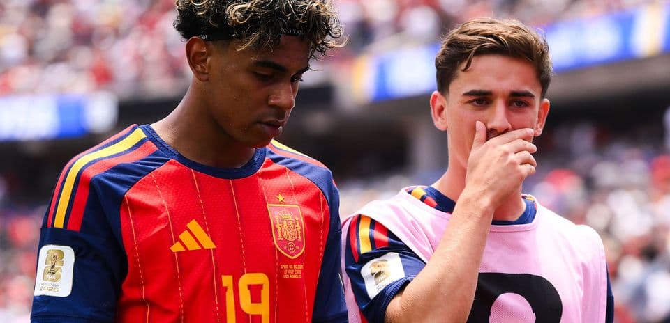 Two Spain players walking off the pitch during match