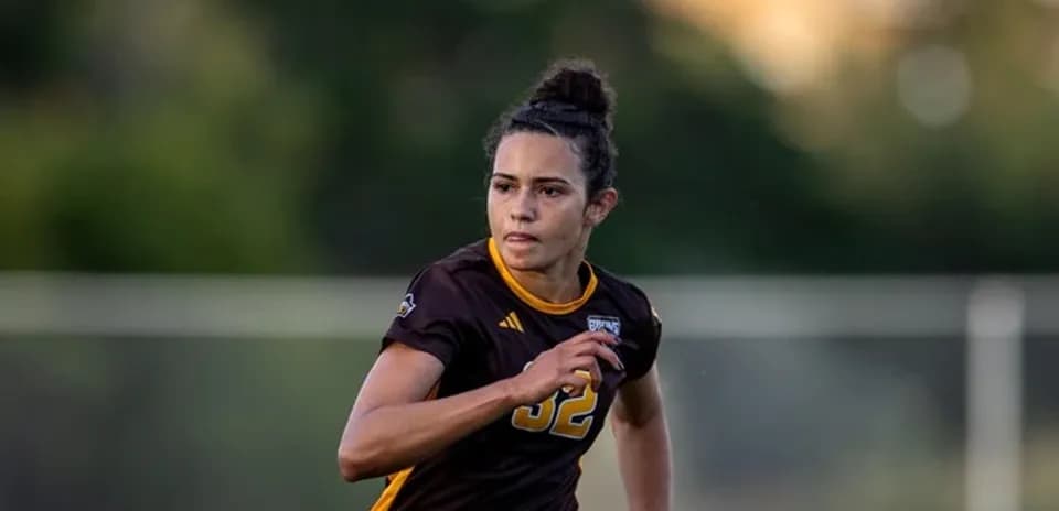 Player in brown jersey sprinting on soccer field