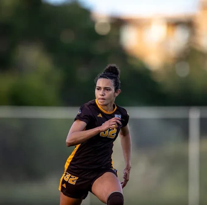 Player in brown jersey sprinting on soccer field