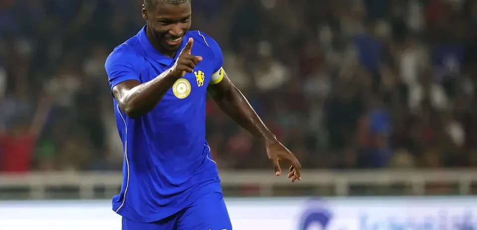 Player celebrating goal with finger raised in stadium