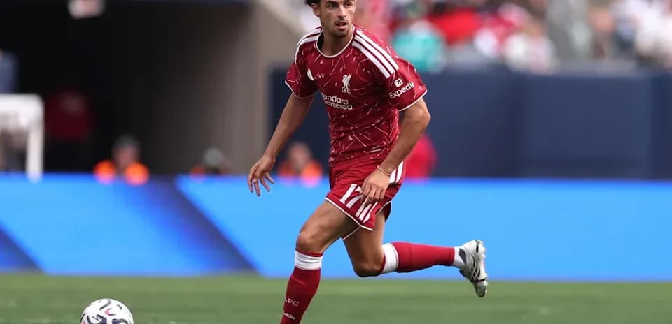 Player in red Liverpool kit dribbling the ball