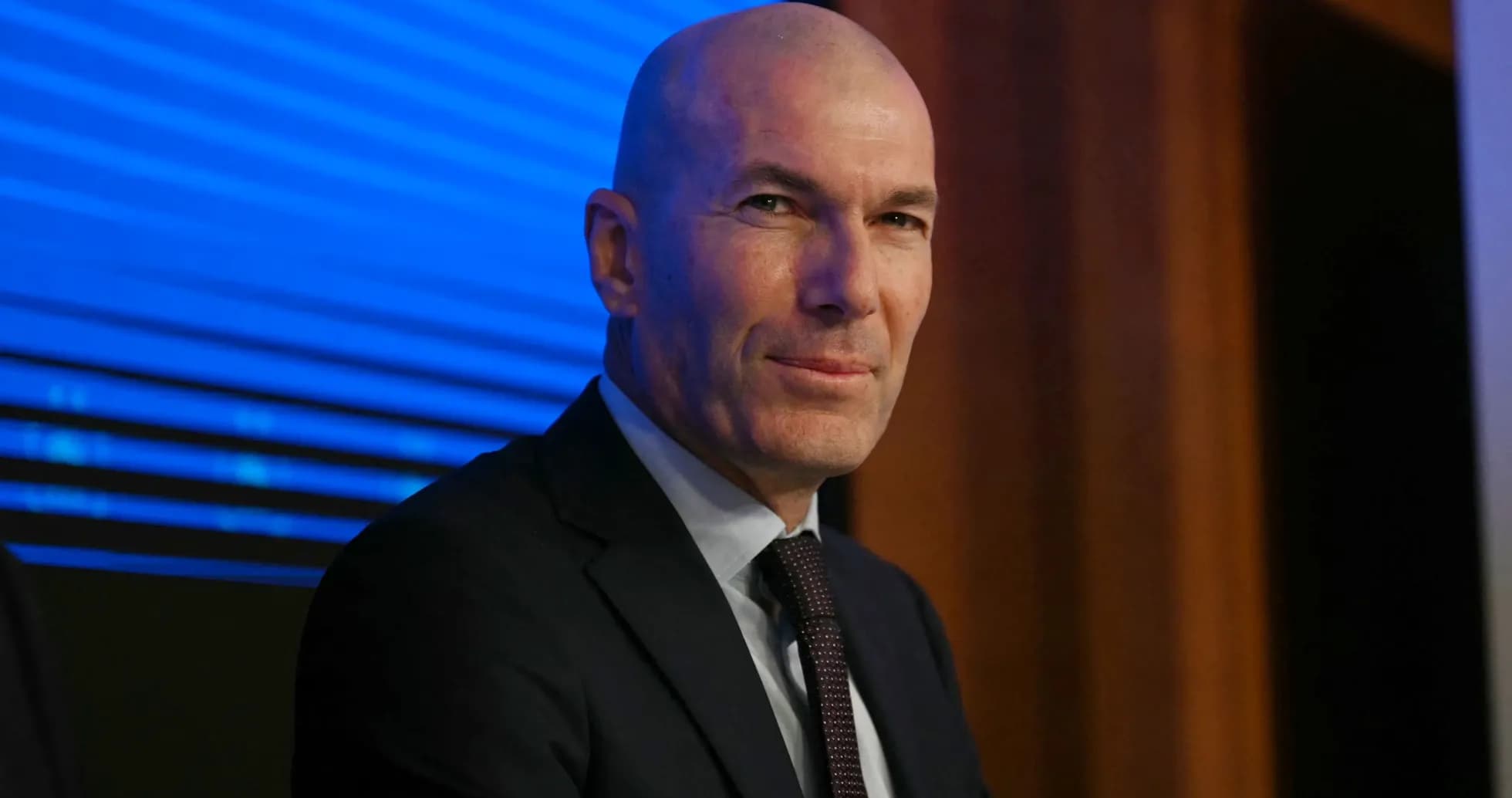 Man in suit sitting at press conference table