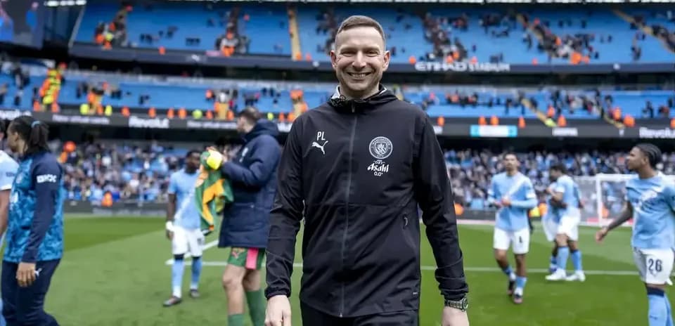 Coach smiling on the pitch after the match