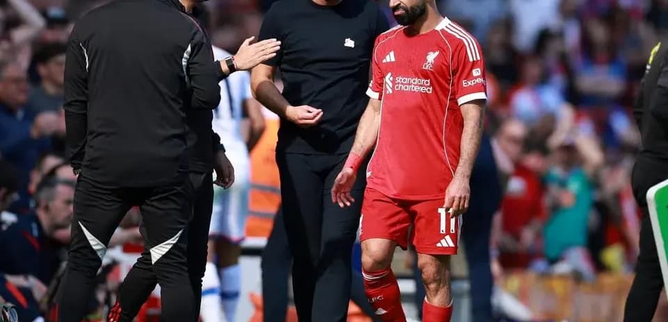 Mohamed Salah walking off the pitch with staff