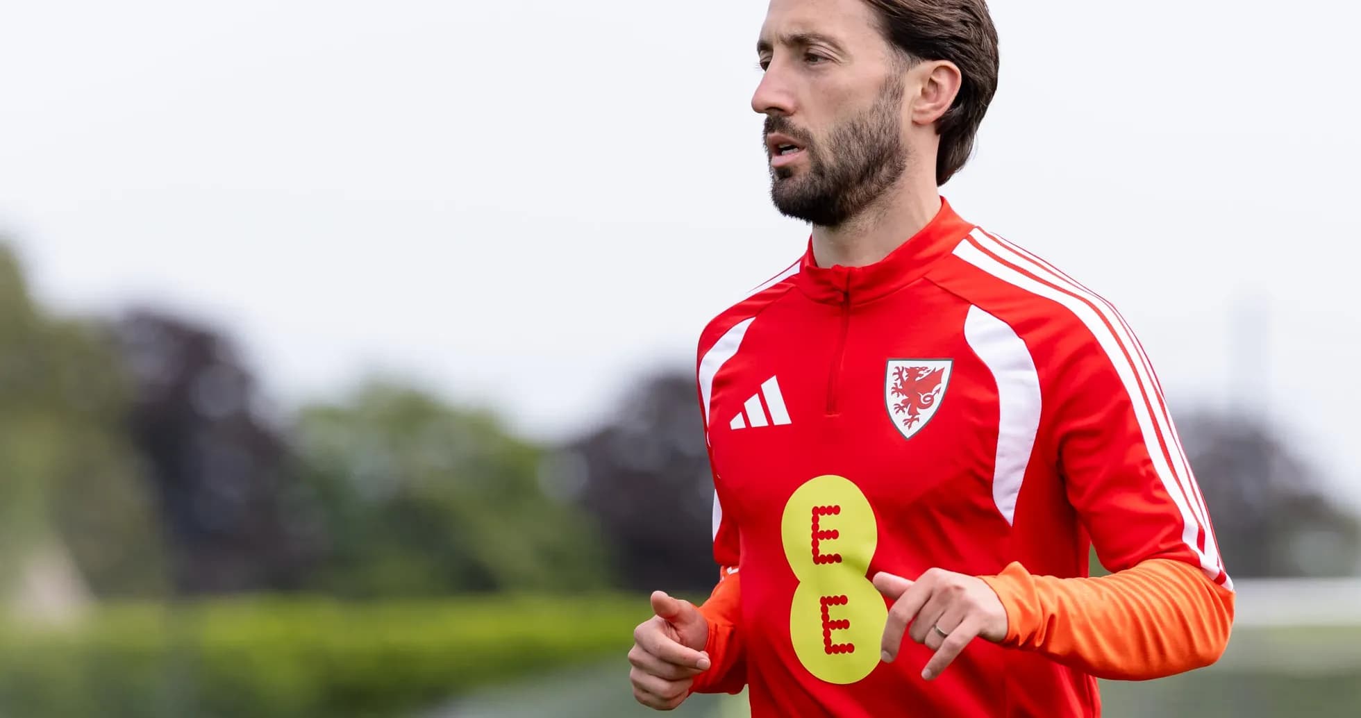 Player in red training kit jogging during practice