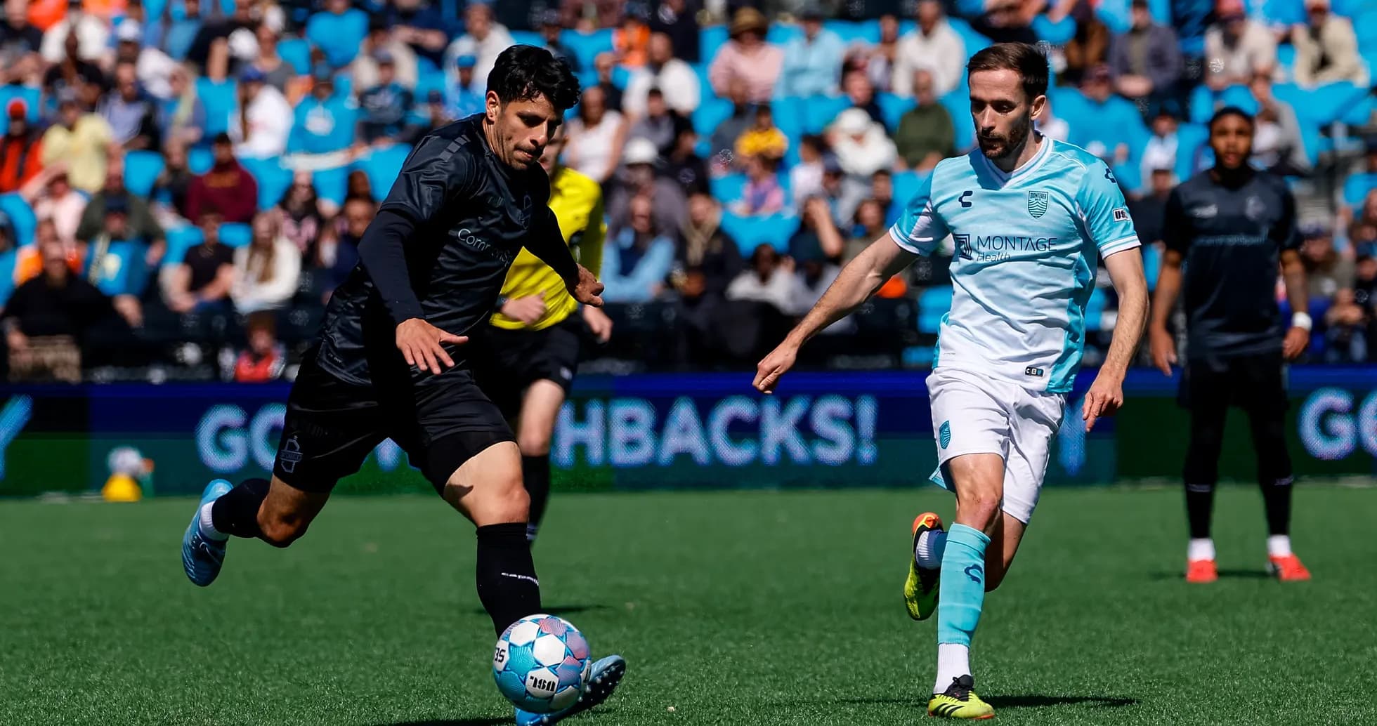 Monterey Bay player dribbling past Loudoun United opponent