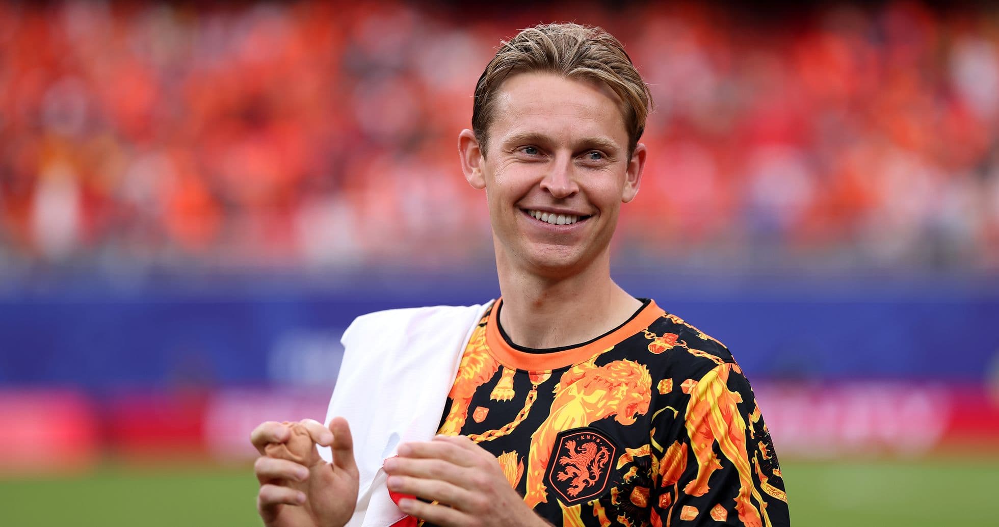 Player smiling and clapping in vibrant jersey
