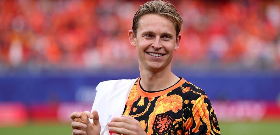 Player smiling and clapping in vibrant jersey