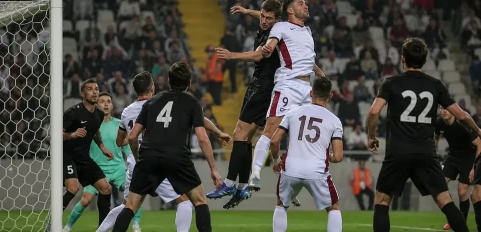 Players jumping for a header in a match
