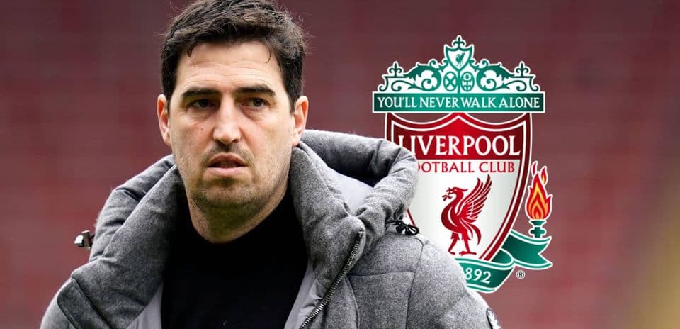 Man in gray coat with Liverpool FC logo background