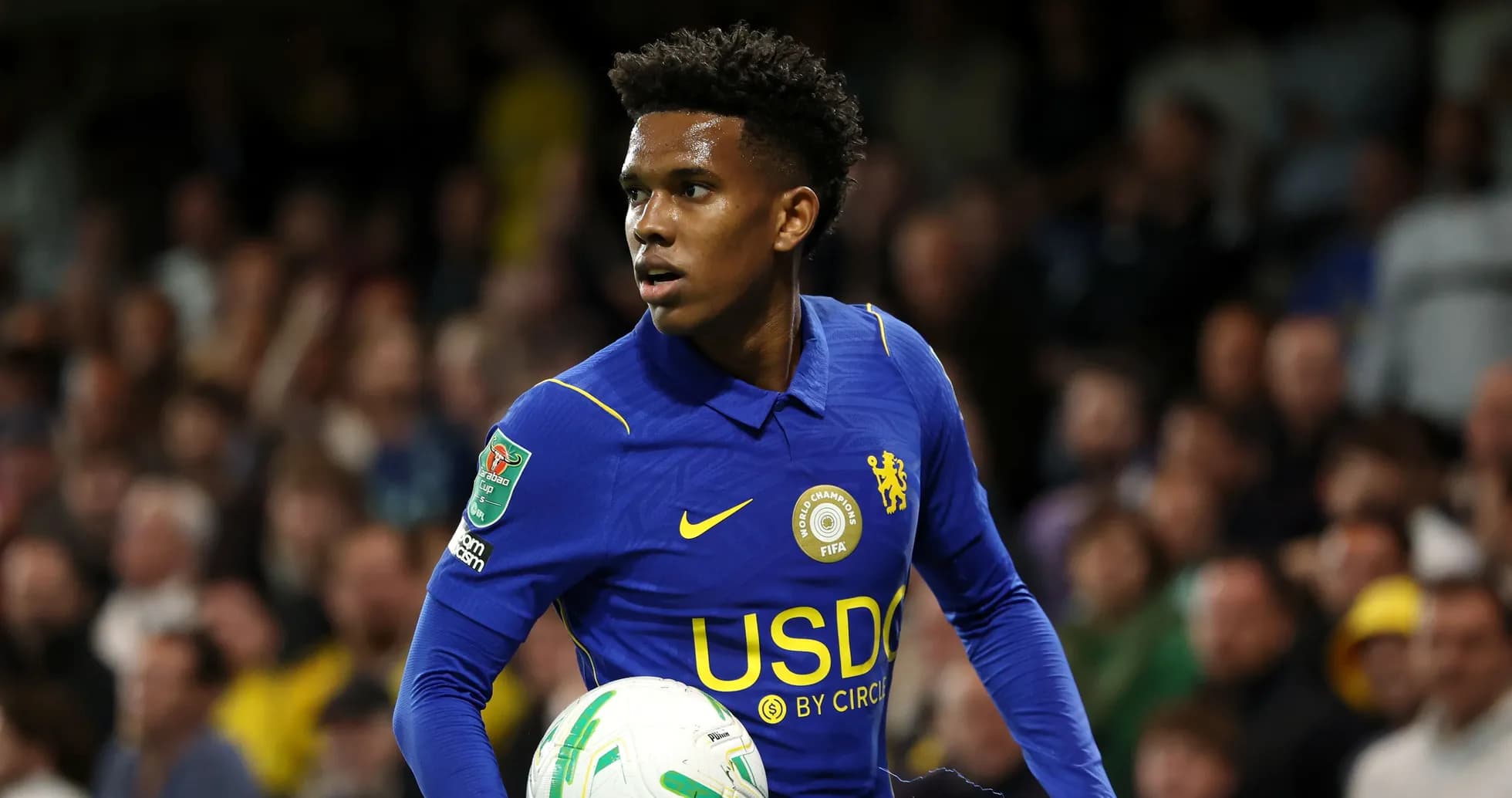 Player in blue jersey holding a football during match