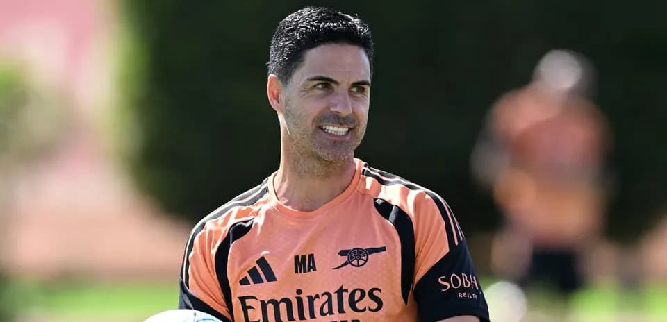 Arsenal manager holding a ball during training session