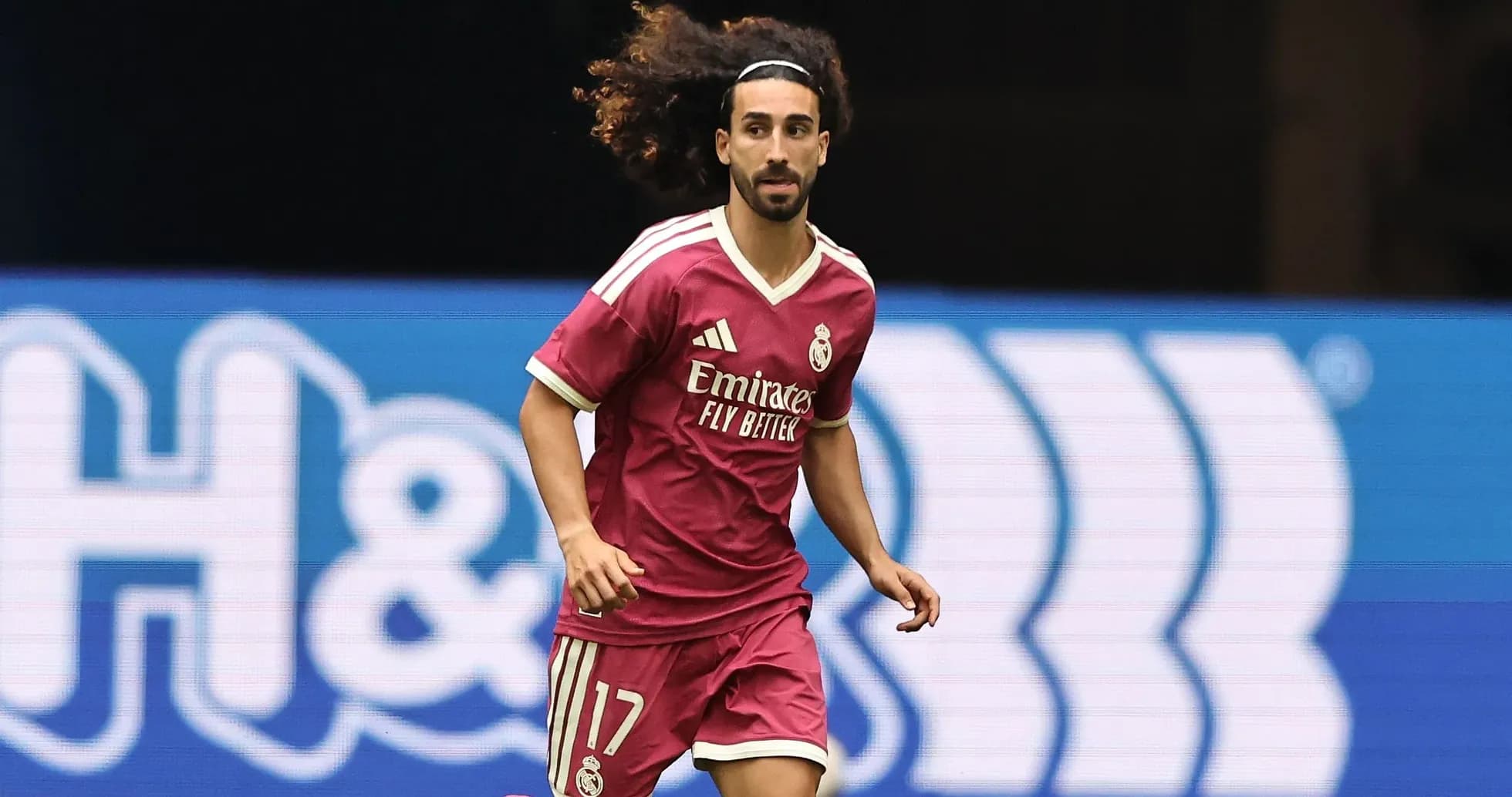 Player running in pink Real Madrid kit on field