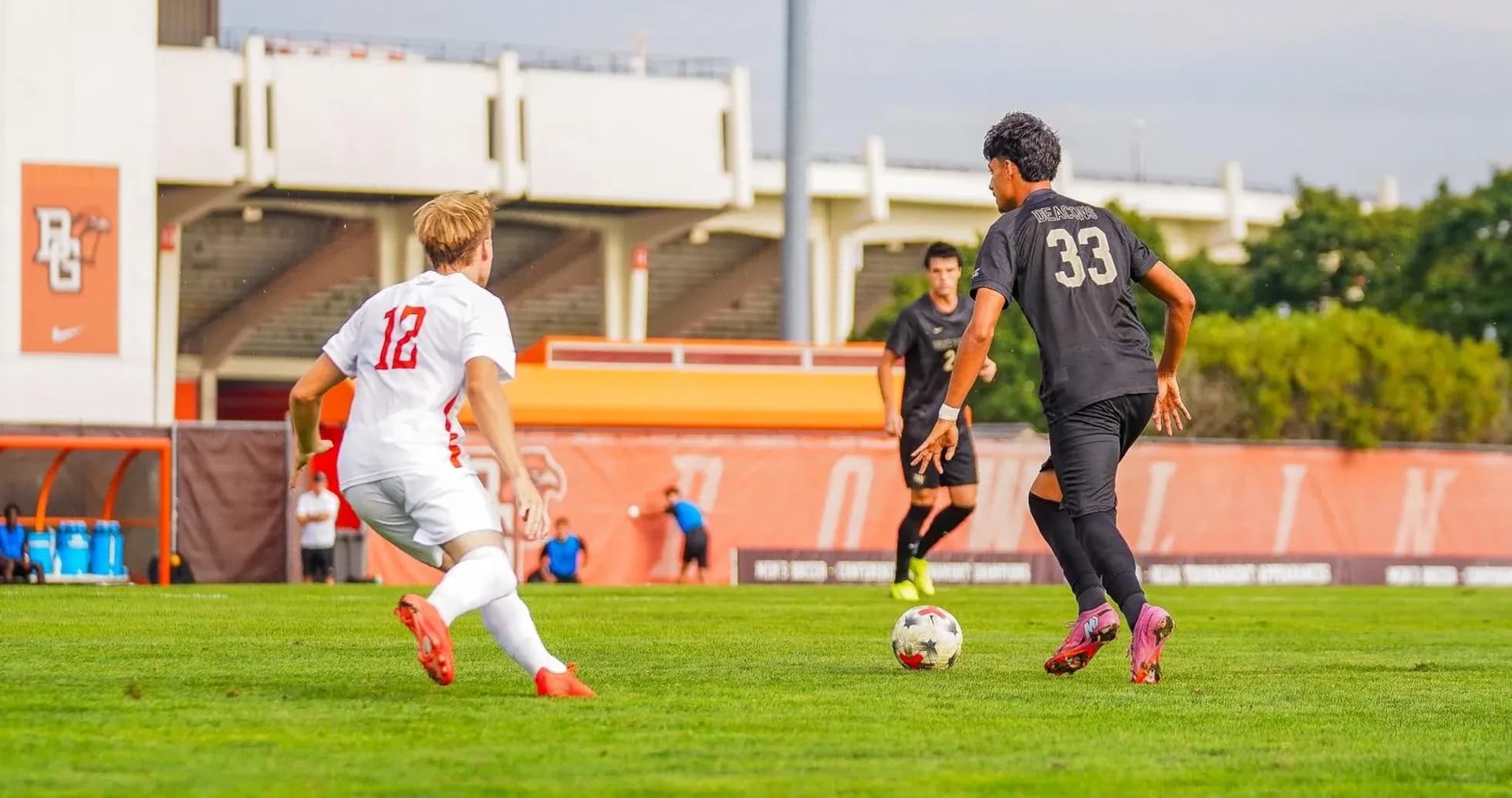 Player 12 dribbling past defender 33 on field