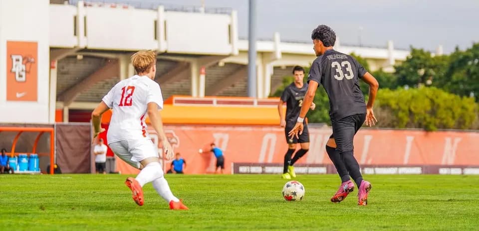 Player 12 dribbling past defender 33 on field