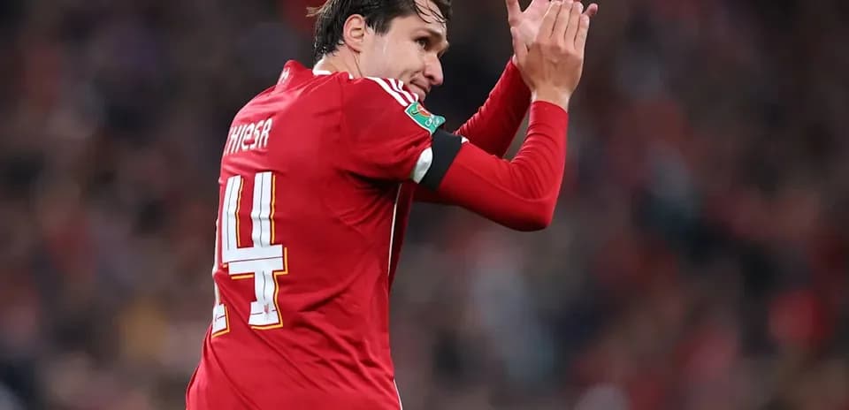 Player applauding fans wearing red team jersey