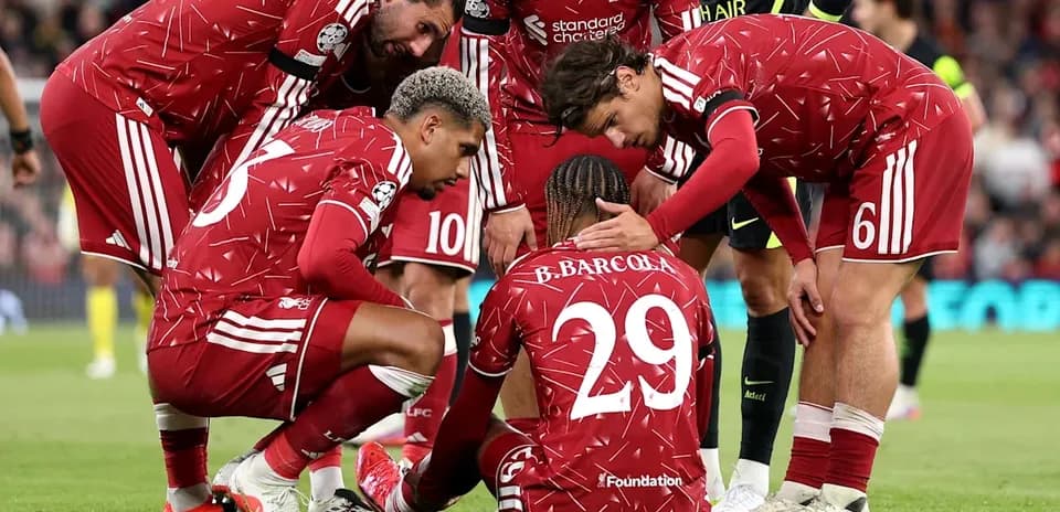 Liverpool players surrounding injured teammate on pitch