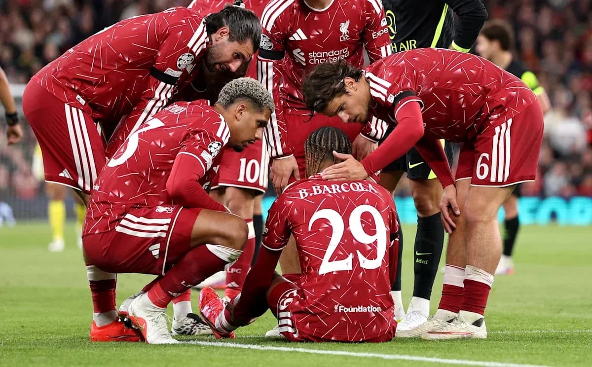 Liverpool players surrounding injured teammate on pitch