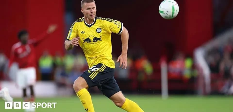 Player in yellow kit chasing a flying football