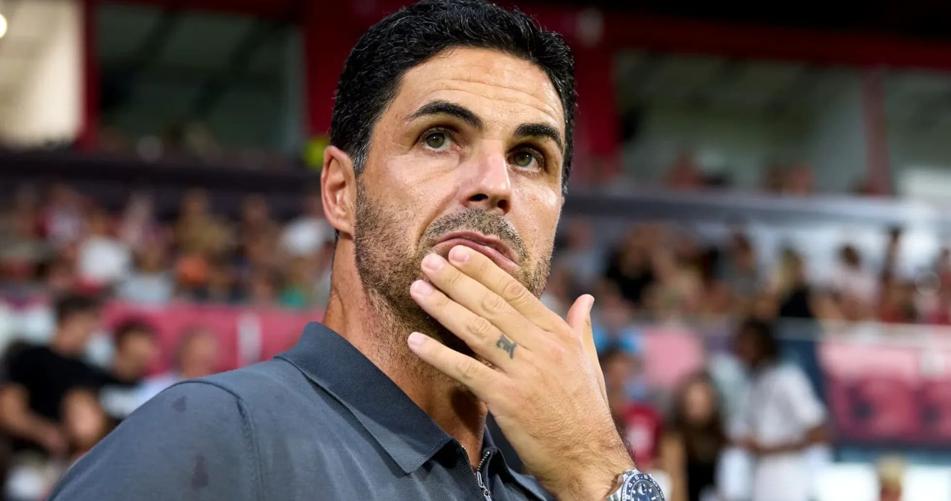 Manager observing the match with thoughtful expression