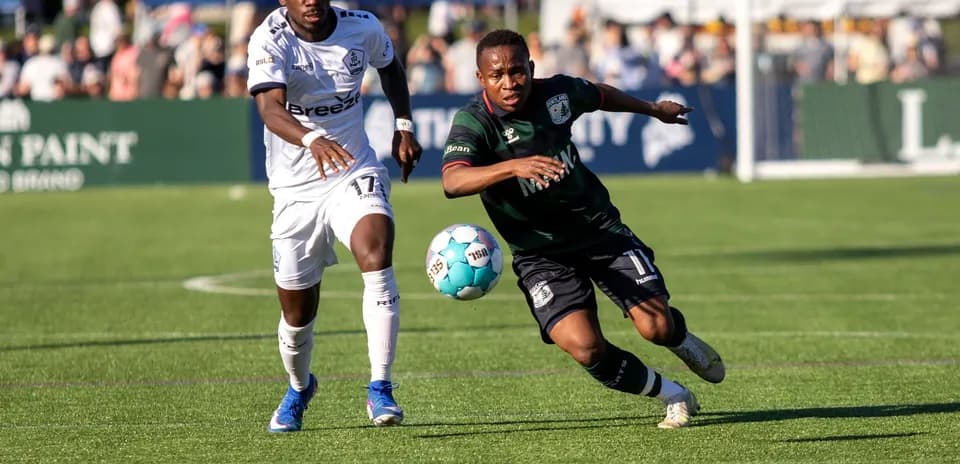 Two players competing for the ball in football match
