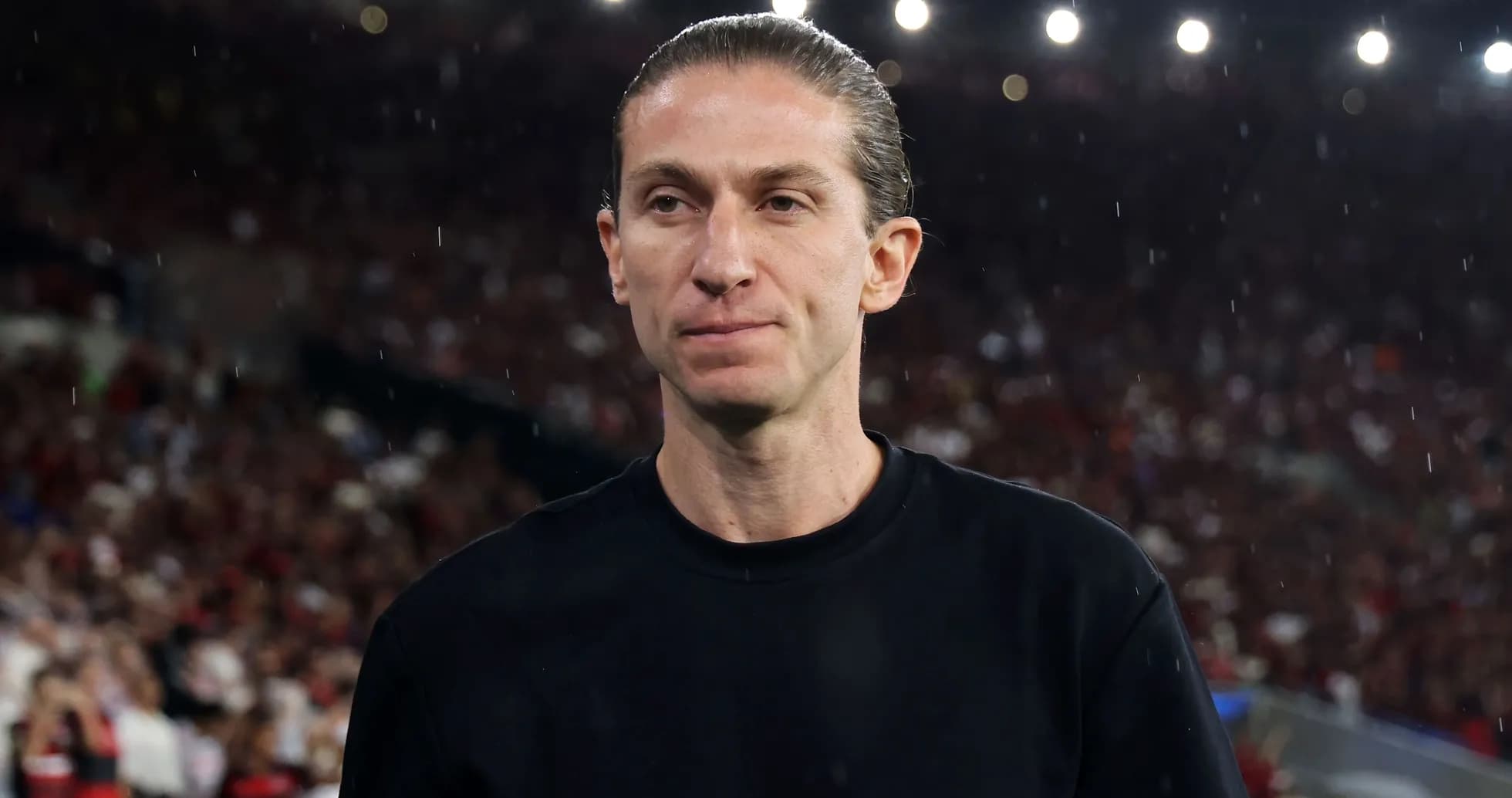 Coach on the sidelines during a rainy match