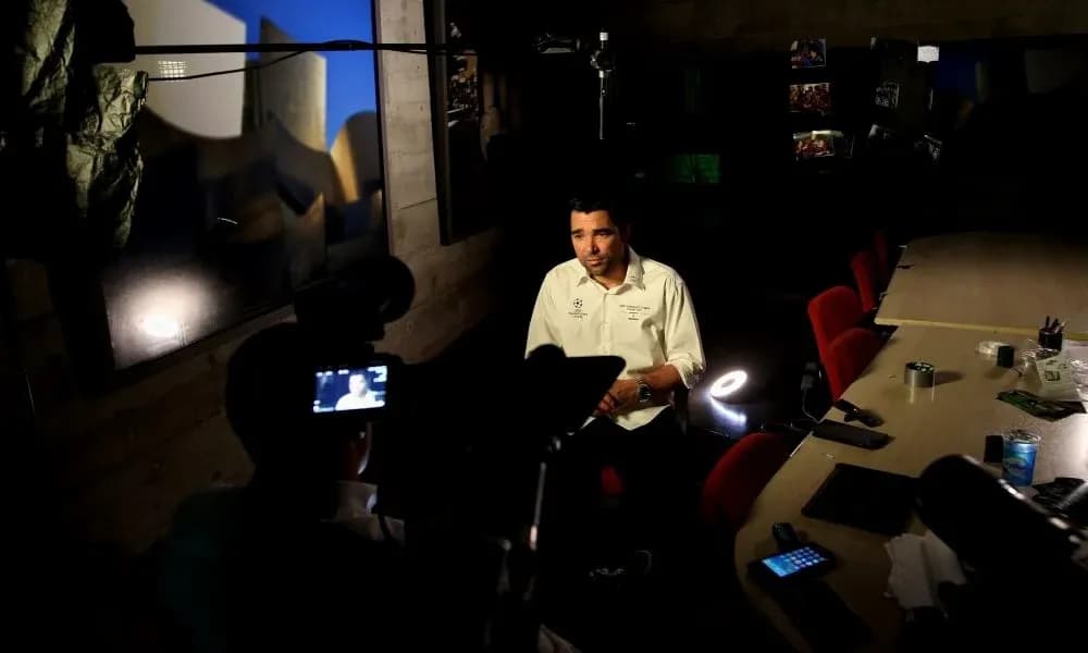 Person being interviewed in a dimly lit room