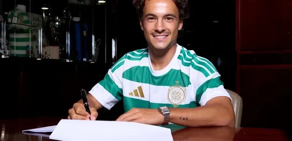 Player signing contract in Celtic jersey at table