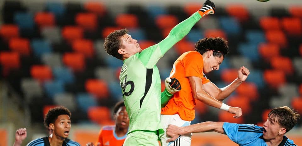 Goalkeeper punches ball during MLS Next Pro match