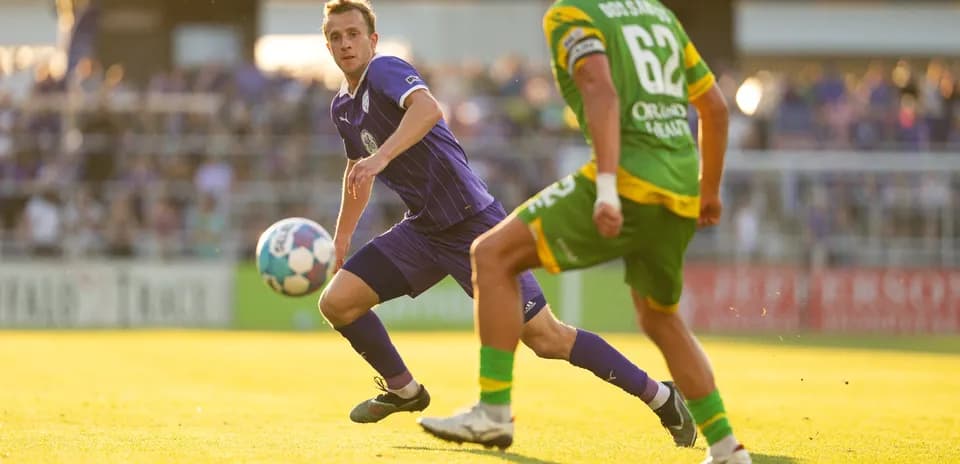 Louisville City player passing the ball during match