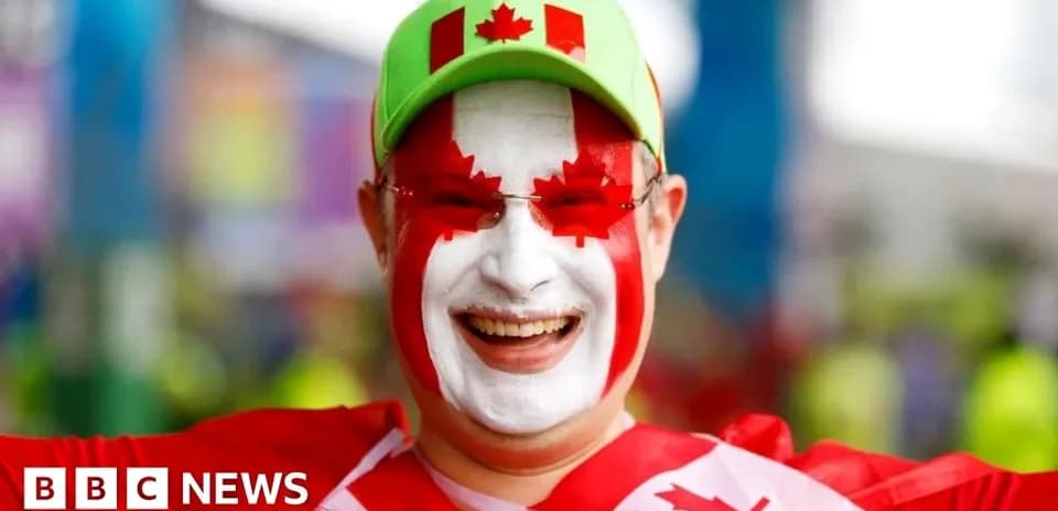 Fan wearing Canadian colors and face paint smiling