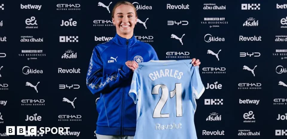 Player holding Manchester City jersey at announcement