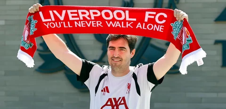 Person holding Liverpool FC scarf outside club building