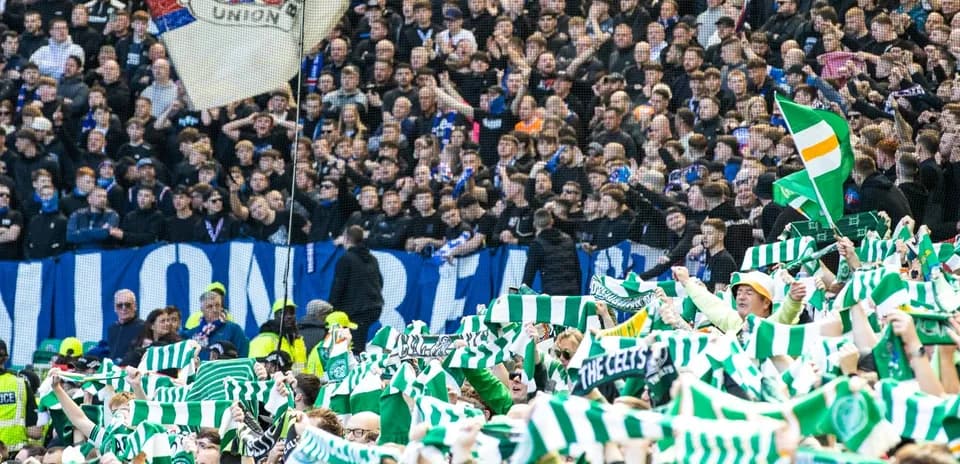 Fans waving scarves in a crowded stadium