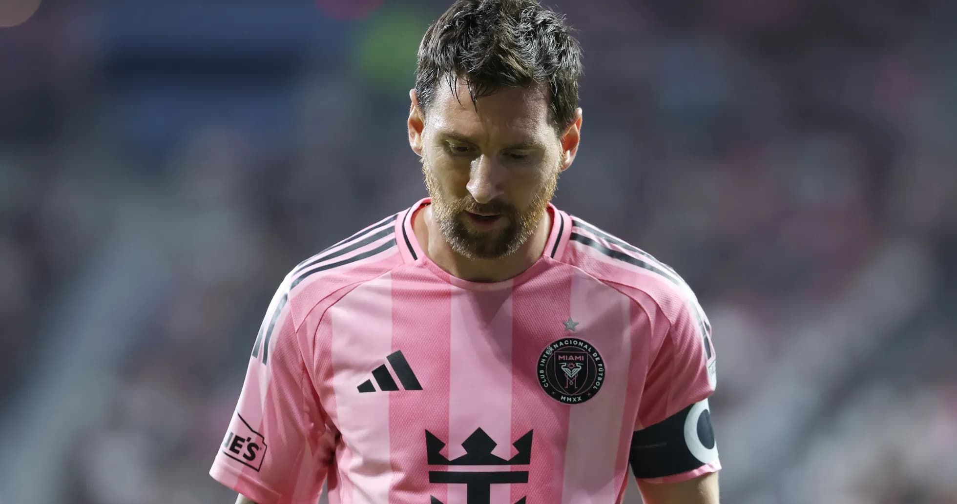 Player in pink jersey walking on field during match