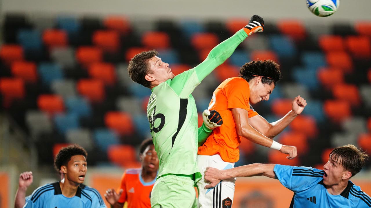 Goalkeeper challenges forward during MLS Next Pro match